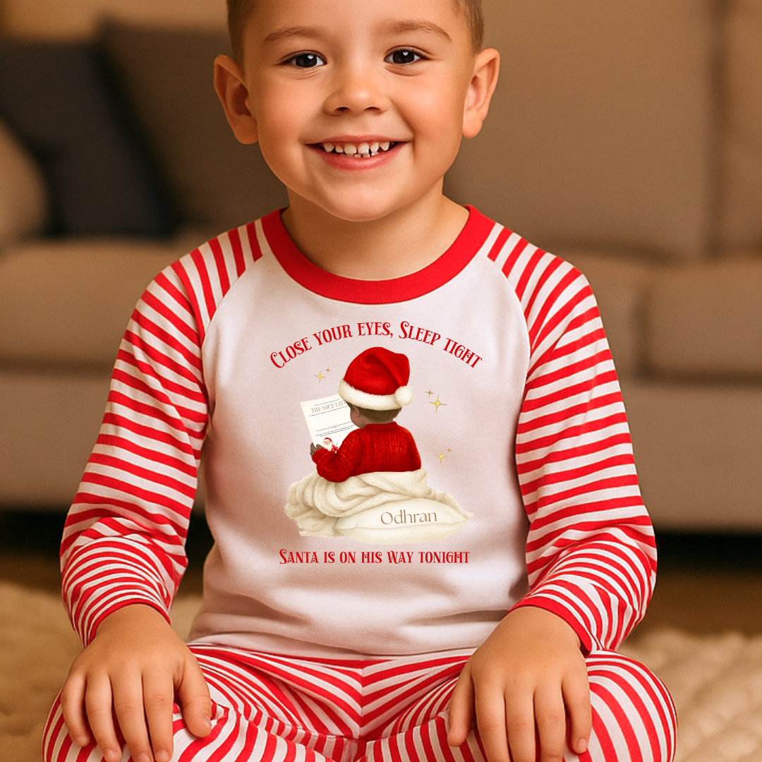 Child wearing red and white striped pajamas with a Christmas-themed design.