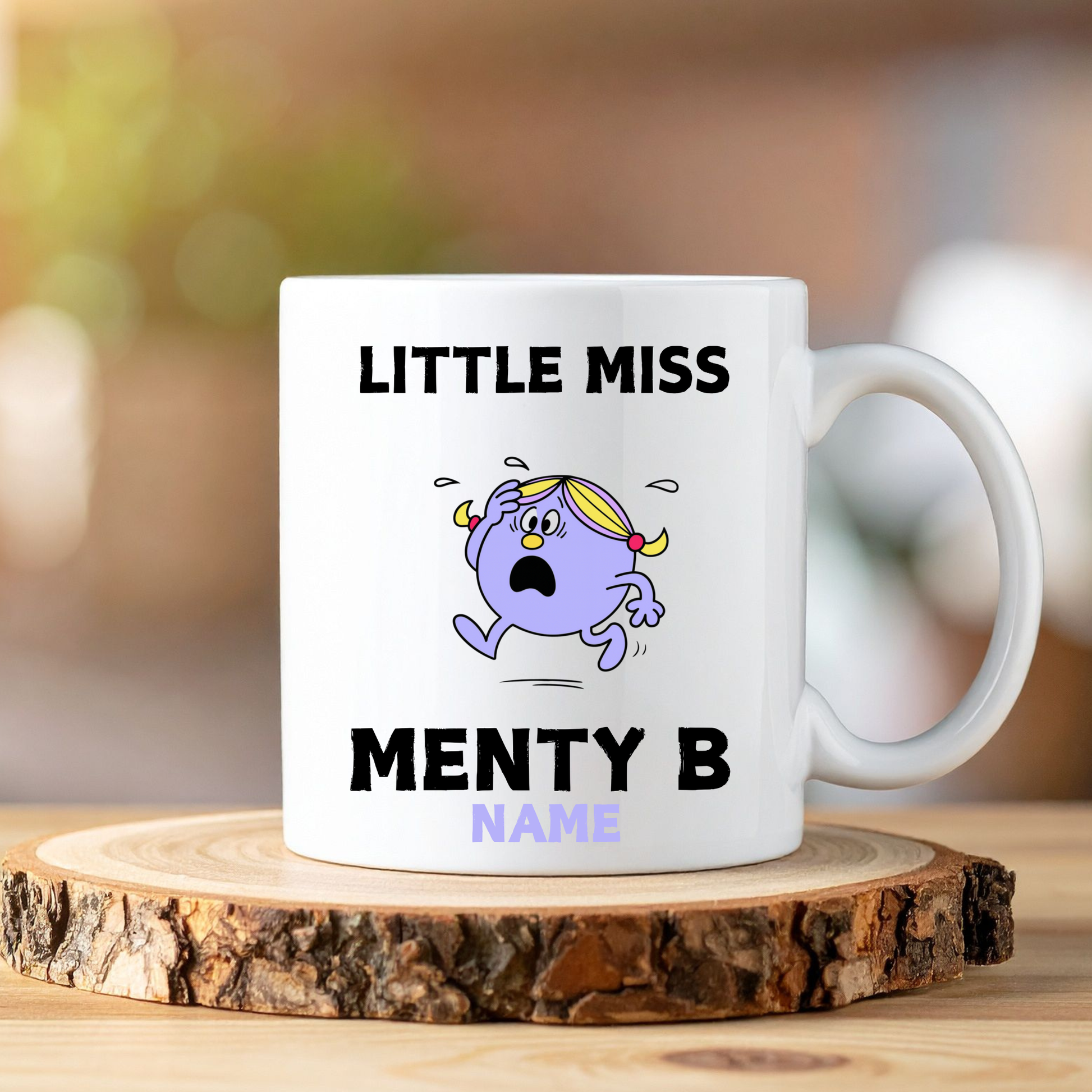 White mug with cartoon character and text on a wooden coaster